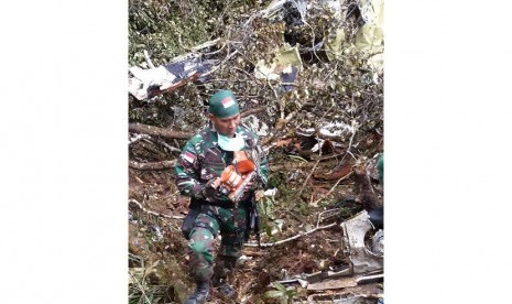 Anggota TNI dari Yonif 133 Sertu Agus Harahap membawa Kotak Hitam (Black Box) pesawat Trigana yang ditemukan di lokasi kecelakaan di Kampung Oksob, Distrik Okbape, Kabupaten Pegunungan Bintang, Papua, Selasa (18/8).