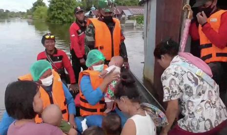 Anggota TNI melakukan evakuasi warga yang terdampak banjir di Palangka Raya.