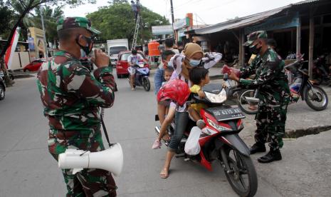 Anggota TNI membagikan masker saat operasi penegakan disiplin protokol kesehatan di Makassar, Sulawesi Selatan