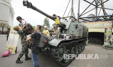 Anggota TNI membantu anak-anak menaiki tank (ilustrasi) 