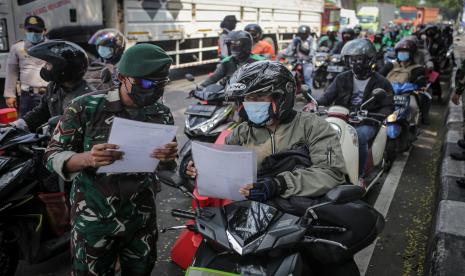 Anggota TNI memeriksa dokumen perjalanan pengemudi yang akan melintas di pos penyekatan pembatasan menuju Jakarta di kawasan Kalideres, Jakarta, Jumat (16/7/2021). Pemerintah memberlakukan waktu pembatasan mobilitas masyarakat yang tersebar pada 100 titik menjadi dua yakni penyekatan pada pukul 06.00-10.00 WIB untuk pekerja sektor esensial dan kritikan serta penutupan pada pukul 10.00-22.00 WIB kecuali tenaga kesehatan, dokter dan kendaraan darurat yang diperbolehkan melintas. 