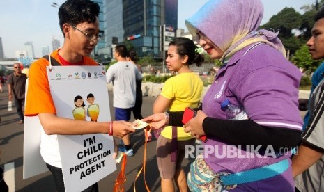 Anggota Wahana Visi Indonesia bersama Forum Anak Jakarta membagikan sebanyak 3000 buku saku perlindungan anak bertema 