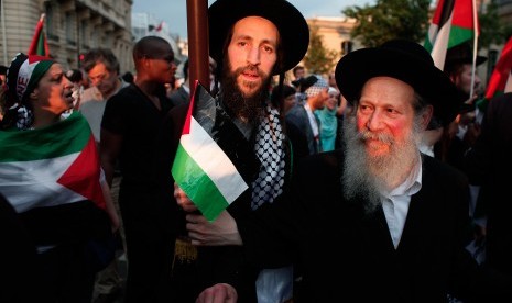 Anggota Yahudi ultra-orthodox, Neturei Karta, kelompok yang menentang zionis dan kependudukan Israel, menggelar aksi menentang serangan Israel ke Gaza di Paris, Prancis, Rabu (23/7).