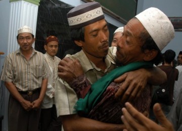 Anggota Jemaat Ahmadiyah Indonesia (kedua dari kanan) berpelukan dengan warga usai mengucapkan dua syahadat di Ciaruteun, Cibungbulang, Bogor, Selasa (15/3).