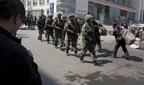 Angkatan bersenjata Cina saat memeriksa area bekas ledakan bom di stasiun kereta api Urumqi, Xinjiang.