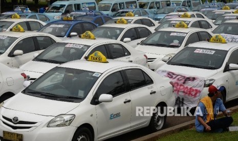 Angkutan umum diparkir di halaman Monas saat ribuan sopi melakukan aksi di depan Balai Kota DKI Jakarta, Senin (14/3). 