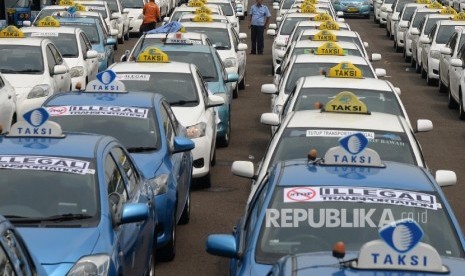 Angkutan umum diparkir di halaman Monas saat ribuan sopi melakukan aksi di depan Balai Kota DKI Jakarta, Senin (14/3). 