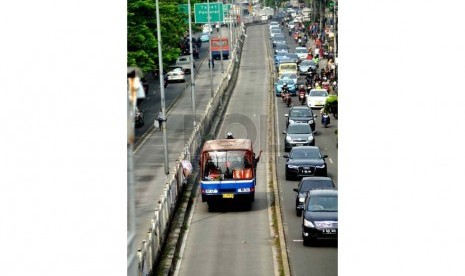  Angkutan umum melintas di jalur Transjakarta (Busway) di Kawasan Manggarai, Jakarta, Selasa (24/6).