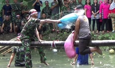 Angota Batalyon Zipur I/Dhira Dharma dan personel Polsek Helvetia, Medan menggelar lomba pukul guling memeriahkan suasana HUR RI ke-72, Kamis (17/8)