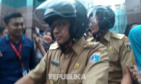 Anies-Sandi kembali ke kediaman mengendarai sepeda motor setelah mengunjungi projek underpass Mampang-Kuningan, Selasa (17/10).