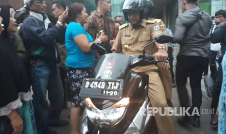 Anies-Sandi kembali ke kediaman mengendarai sepeda motor setelah mengunjungi projek underpass Mampang-Kuningan, Selasa (17/10).