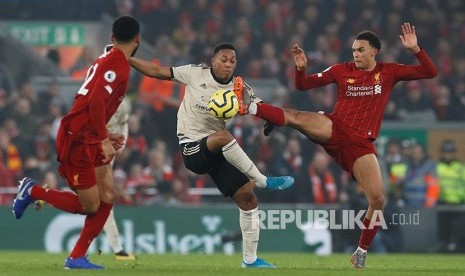 Anthony Martial diadang Trent Alexander-Arnold (kanan) pada laga Liverpool melawan Manchester United di Anfield Stadium, Liverpool, Senin (20/1) dini hari