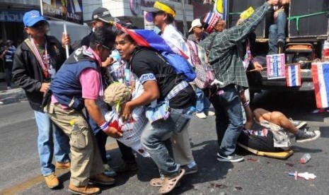 Anti-government protesters help a fellow protester injured in a grenade attack during a rally in Bangkok in this January 17, 2014.