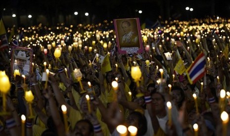 Anti-government protesters hold candles as they take part in birthday celebrations for Thailand's revered King Bhumibol Adulyadej, at the occupied government complex in Bangkok December 5, 2013. 