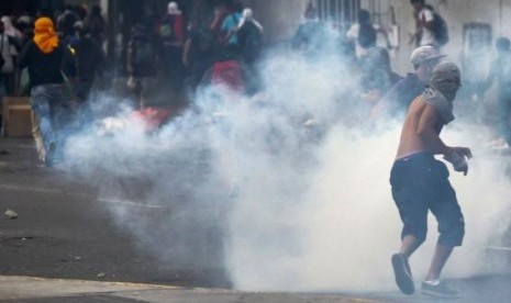 Anti-government protesters run from tear gas during a protest against Nicolas Maduro's government in Caracas March 13, 2014.