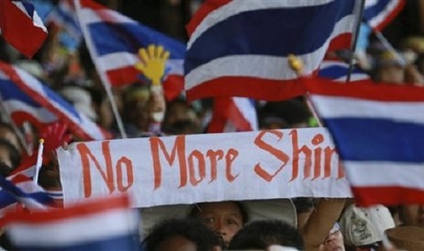 Anti-government protesters wave a banner and Thai national flags as they rally outside the Government complex in Bangkok, Thailand, Wednesday, Nov. 27, 2013.