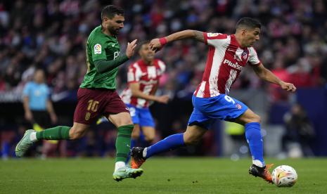 Antonio Puertas dari Granada, kiri, menantang Luis Suarez dari Atletico Madrid selama pertandingan sepak bola La Liga Spanyol antara Atletico Madrid dan Granada di stadion Wanda Metropolitano di Madrid, Spanyol, Rabu, 20 April 2022.