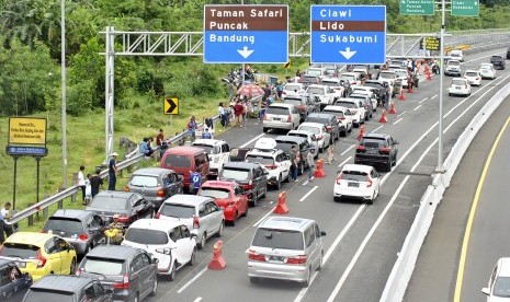 Antrean kendaraan memadati pintu keluar gerbang tol Ciawi menuju jalur Puncak, Kabupaten Bogor, Jawa Barat, Selasa (25/12/2018).