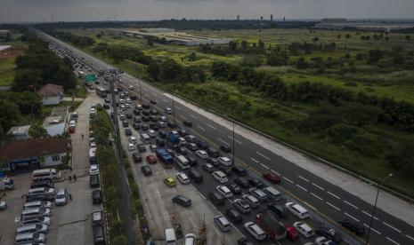 Antrean kendaraan menuju arah Jakarta di Gerbang Tol Cikampek Utama, Karawang, Jawa Barat, Jumat (6/5/2022). Pada H+3 Lebaran 2022, ruas Jalan Tol Jakarta-Cikampek mengalami kepadatan volume kendaraan sehingga diberlakukan sistem one way.