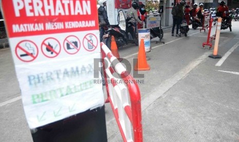  Antrean pengendara sepeda motor untuk mengisi BBM di Stasiun Pengisian Bahan Bakar Umum (SPBU) di Jakarta, Rabu (30/12). 