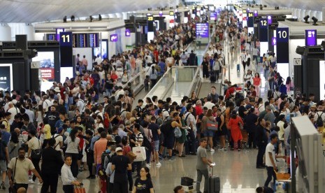 Antrean penumpang mengular di terminal kedatangan di Bandara Internasional Hong Kong di Hong Kong akibat aksi protes, Senin (12/8).