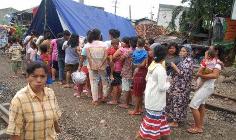 Antrean warga korban banjir di posko kesehatan kawasan Pasar Pesing, Kedoya Utara, Jakarta Barat, Rabu (15/1).    (Republika/Rakhmawaty La'lang)