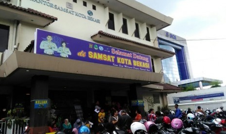 Antrean warga membludak di Kantor Samsat Kota Bekasi, Jalan Ahmad Yani, Kamis (5/1). Antrean ini sampai menimbulkan kemacetan lalu lintas sepanjang +/- 150 meter di depan Kantor Samsat.