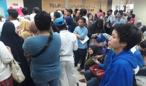 Antri Legalisir KK--Ribuan orang tua murid mengantri di Dinas Kependudukan dan Catatan Sipil (Disdukcapil) Kota Depok untuk melegalisir Kartu Keluarga (KK), Jumat (14/6).