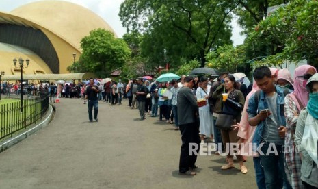 Warga mengantri untuk melakukan perekaman dan cetak e-KTP di lapangan parkir Teater Imax Keong Mas TMII, Jakarta, Jumat (20/10). 