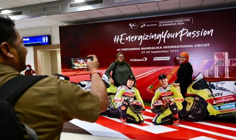 Antusias wisatawan saat berfoto di spot foto unik dengan papan menyerupai pembalap Tim VR46 MotoGP yang ada di Bandara Internasional Lombok. Selasa (24/9/2024).