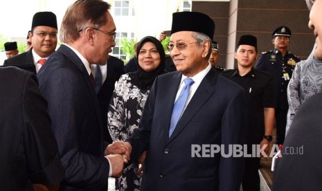  Anwar Ibrahim berjabat tangan dengan Mahathir Mohamad. 