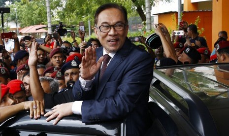 Anwar Ibrahim melambaikan tangan saat dinyatakan bebas seusai keluar dari rumah saki, Rabu (16/5).