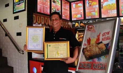 Anwar Syafei memamerkan sertifikat halal dari MUI untuk restoran Dioz Chicken miliknya.