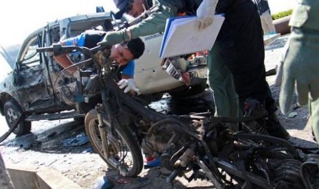 Aparat keamanan memeriksa bangkai sepeda motor yang dijadikan bom oleh pemberontak di Provinsi Yala, Thailand selatan.