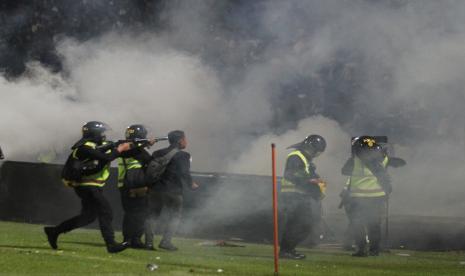 Aparat keamanan menembakkan gas air mata untuk menghalau suporter yang masuk lapangan usai pertandingan sepak bola BRI Liga 1 antara Arema melawan Persebaya di Stadion Kanjuruhan, Malang, Sabtu (1/10/2022).