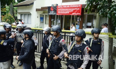 Aparat kepolisian bersenjata lengkap berjaga-jaga saat olah TKP terkait pelaku peledakan bom yang berhasil dilumpuhkan, di kantor kelurahan Arjuna , Kota Bandung, Senin (27/2).