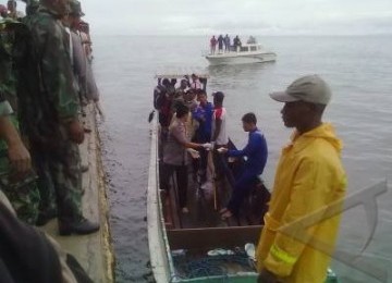 Aparat Kepolisian dibantu warga mengevakuasi jenasah yang menjadi korban jatuhnya pesawat Merpati MA-60 PK di Kaimana, Papua Barat, Ahad (8/5).