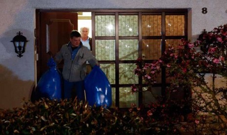 Aparat kepolisian Jerman mengangkut dua kantung plastik warna biru dari rumah orang tua copilot Germanwings, Andreas Lubitz, di Montabaur, Jerman, Kamis (26/3).