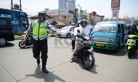  Aparat kepolisian memeriksa kelengkapan surat kendaraan pengendara motor saat menggelar operasi Zebra Jaya 2014 di Jalan Margonda Raya, Depok, Jumat (28/11).    (Republika/Raisan Al Farisi)