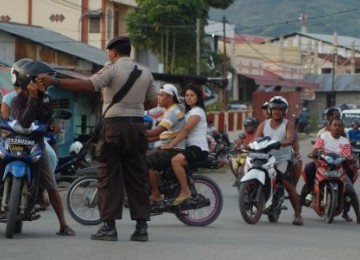 Aparat Kepolisian mengalihkan warga yang akan melintas di Jalan Utama paska bentrok antar warga di Pasar Lama, Abepura, Jayapura, Papua.