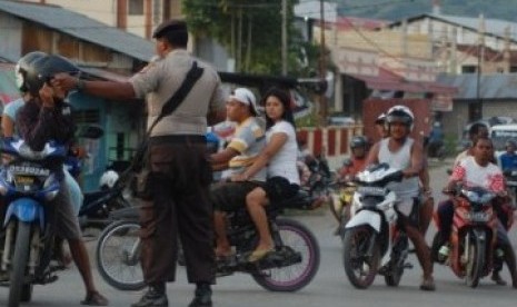 Aparat Kepolisian mengalihkan warga yang akan melintas di Jalan Utama Jayapura, Papua.