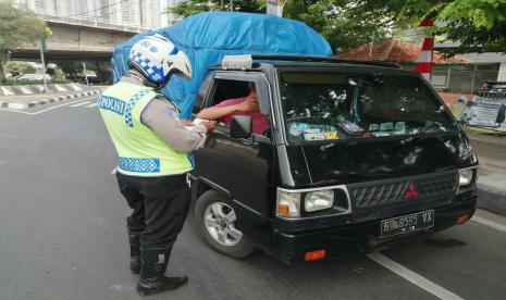 Aparat kepolisian menindak kendaraan roda empat yang melanggar sistem ganjil-genap di Jalan S Parman, Jakbar, Senin (10/8).