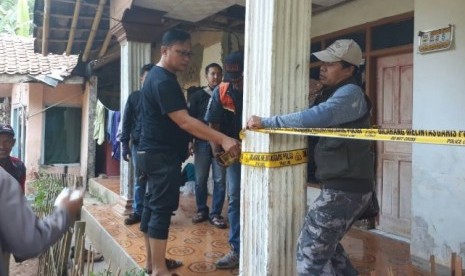 Aparat polres Cimahi memasang garis polisi di rumah AS, warga RT 02 Kampung Ciranji, Desa Sirnagalih, Kecamatan Cipongkor, Kabupaten Bandung Barat yang diduga pelaku bom bunuh diri di Kampung Melayu.