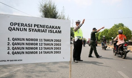 Aparat Wilayatul Hisbah (polisi syariat islam) Provinsi Aceh dibantu Polisi lalu lintas Polda Aceh dan Polisi Militer Kodam Iskandar Muda menggelar operasi penegakkan qanun (peraturan daerah) syariat islam di Banda Aceh, Aceh, Selasa (24/3).