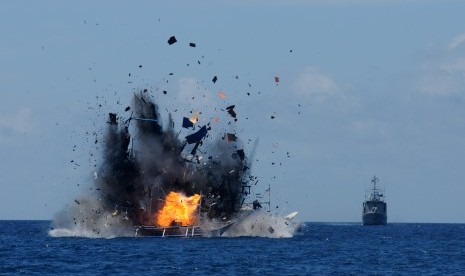 Api dan asap keluar dari lambung kapal nelayan asing pelaku ilegal fishing yang ditenggelamkan di perairan Bitung, Sulawesi Utara, Rabu (20/5).  (Antara/Fiqman Sunandar)