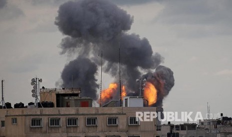 Api dan asap tampak dari gedung yang dihantam serangan udara militer Israel di selatan Jalur Gaza, Senin (24/2).