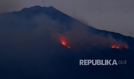 Api membakar hutan di lereng Gunung Arjuno terlihat dari Desa Landungsari, Malang, Jawa Timur, Jumat (11/10/2019).