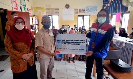 Area Manager Communication, Relations, & CSR PT KPI Unit Balongan Imam Rismanto menyerahkan bantuan kepada Dedi Suswedi yang hadir mewakili ketua yayasan dan Cicih Arningsih selaku kepala sekolah SLB Mutiara Hati, Jumat (3/12).