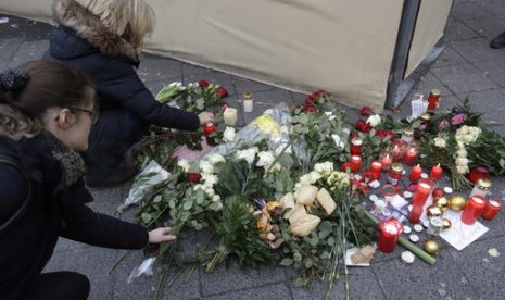 arga meletakkan bunga dekat lokasi truk yang menabrak kerumunan orang di pasar Natal di Berlin, Jerman, Selasa, 20 Desember 2016.