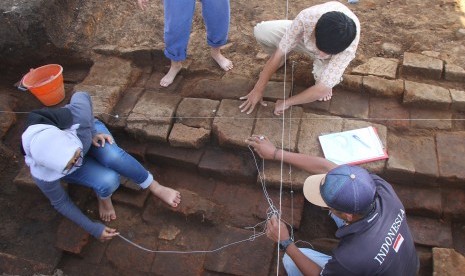 Arkeolog dari tim Balai Pelestarian Cagar Budaya (BPCB) Trowulan melakukan eskavasi pada struktur bata kuno yang ditemukan di Situs Pendem, Batu, Jawa Timur, Sabtu (14/12).